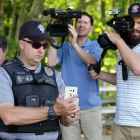 A first responder shows their aerial cell phone connectivity to members of the media.